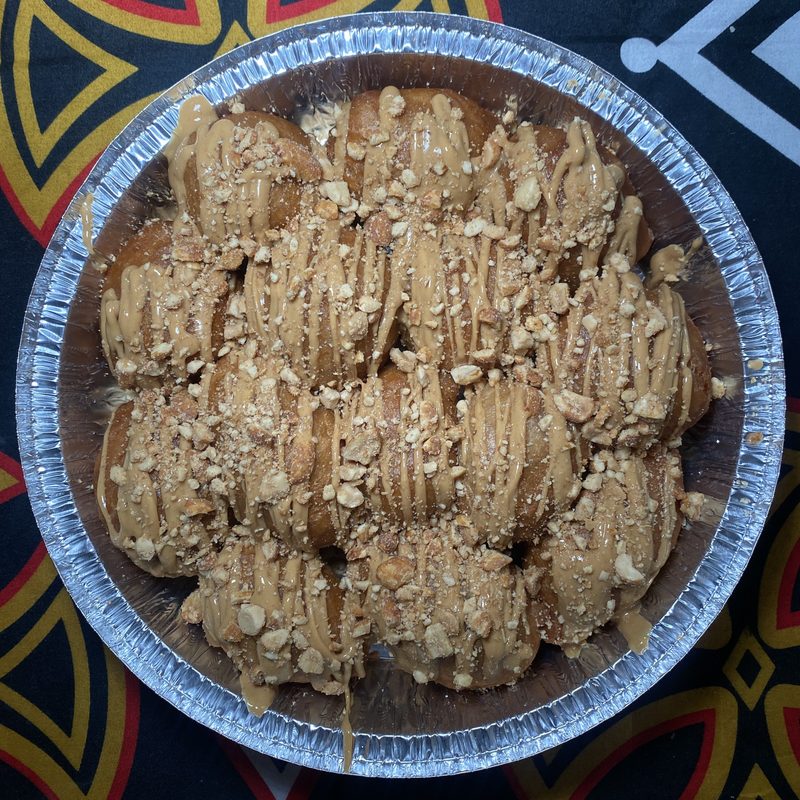 Groundnut beignets with peanut butter drizzle and honey roasted peanuts