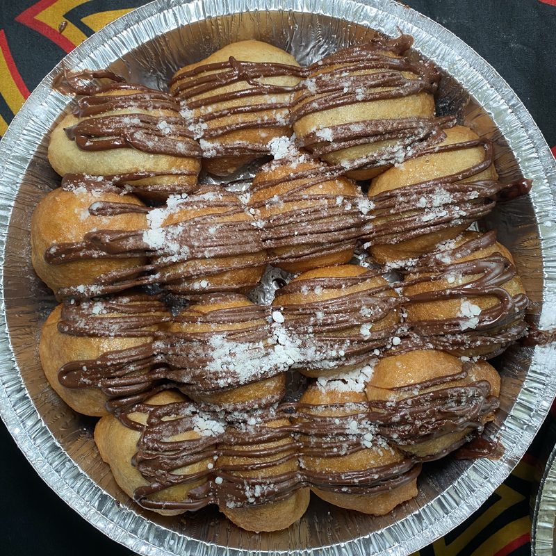 Beignets drizzled with Nutella and finished with powdered sugar